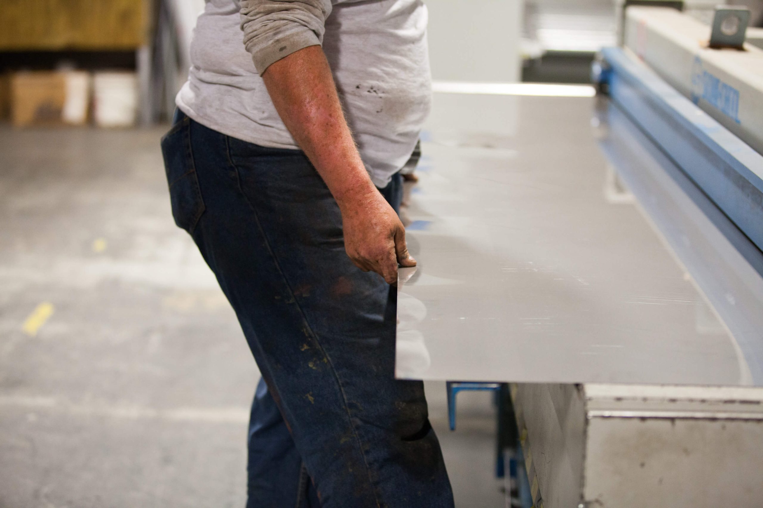 Man holding sheet metal on metal brake