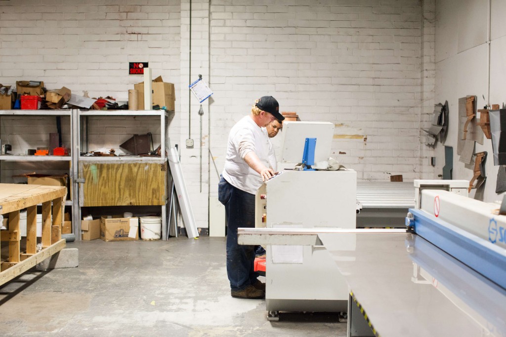 Two men in metal shop working on sheet metal