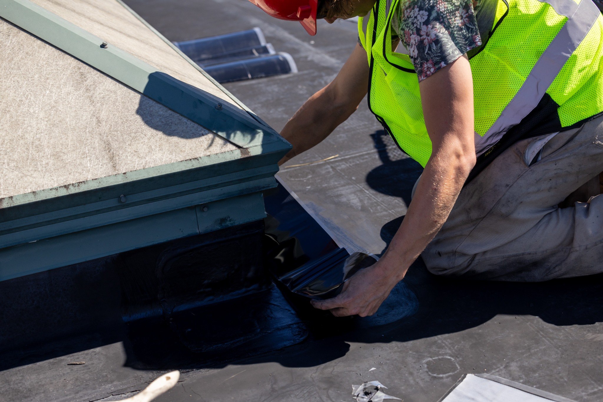 Roofer in safety gear installing materials